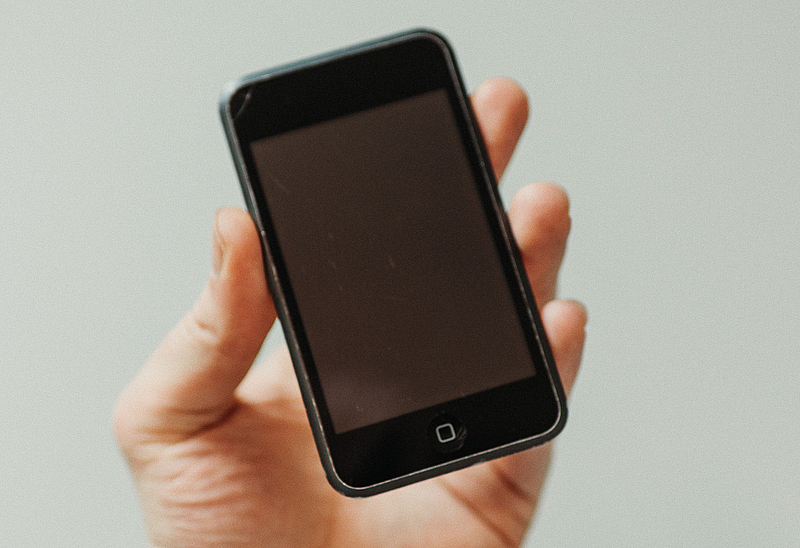 Eine Hand hält einen iPod touch mit schwarzem Bildschirm