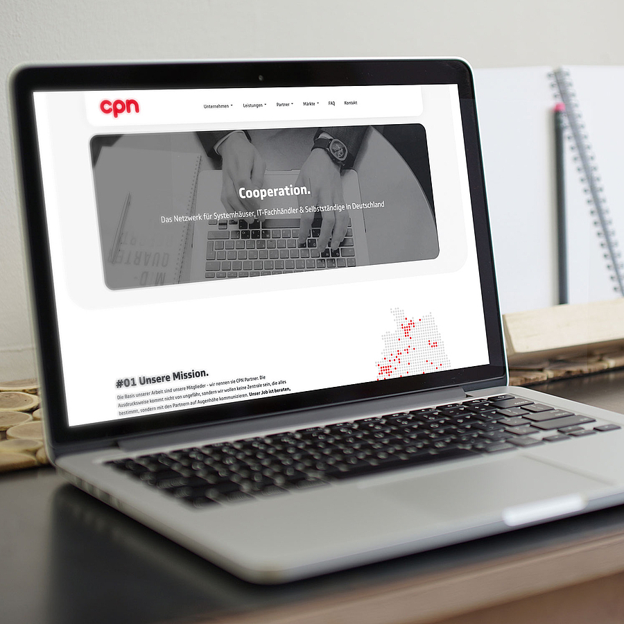 Schreibtisch mit geöffnetem Laptop und einer Maus