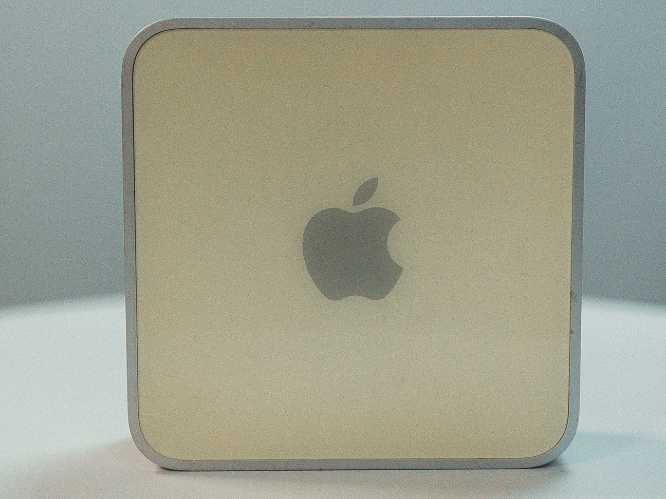 viereckiger Mac mini mit weißer Oberfläche, silbernem Gehäuse und silbernem Apple Logo