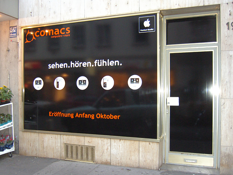 zugeklebte Fensterfront, weiße Schrift auf schwarzem Hintergrund sagt sehen hören fühlen. In orangen Schrift untendrunter: Eröffnung Anfang Oktober