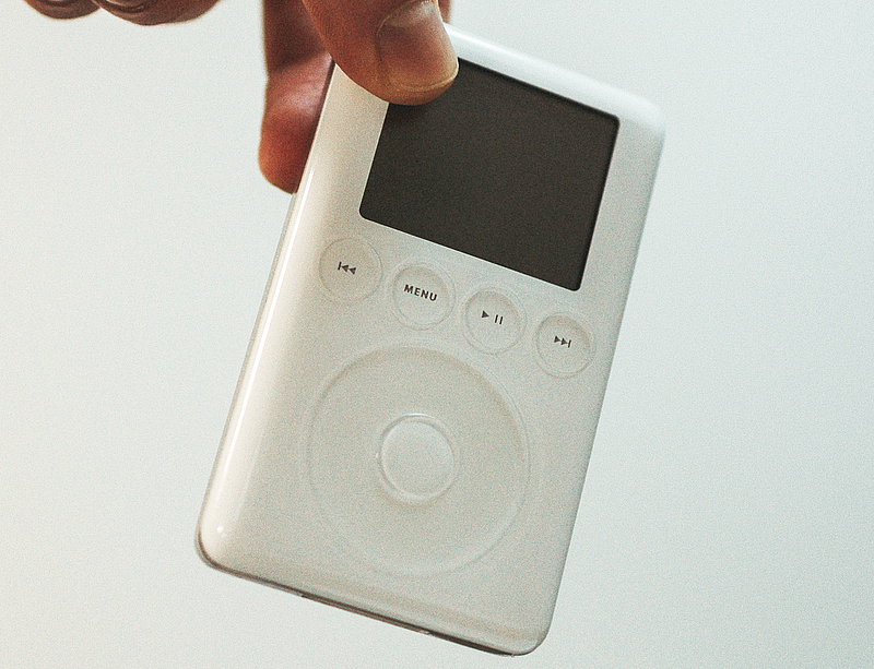 Daumen und Zeigefinger halten einen iPod der 3. Generation